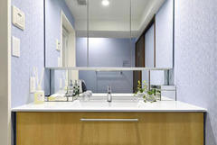 ブルーの壁と木目のコントラストが美しいさわやかな洗面室。