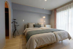 グレイッシュな壁が落ち着きを演出する寝室。※寝具類はCG