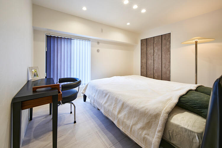 落ち着いたトーンで整えた寝室。海を思わせるブルーグラデーションの窓まわり